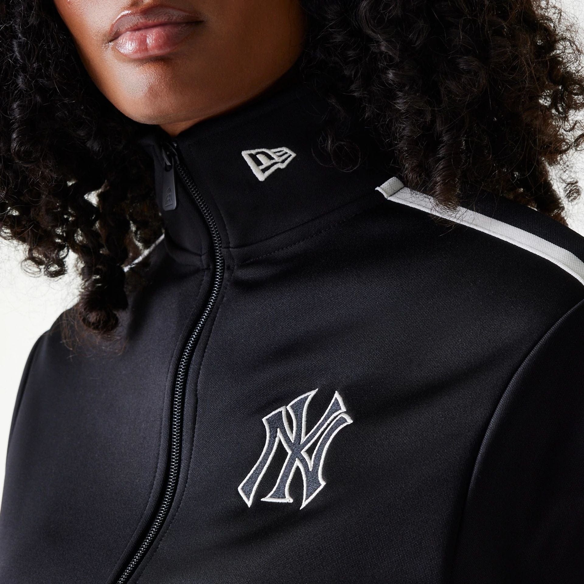 The Female model is wearing New York Yankees Womens MLB Midi Logo Black Track Jacket 8