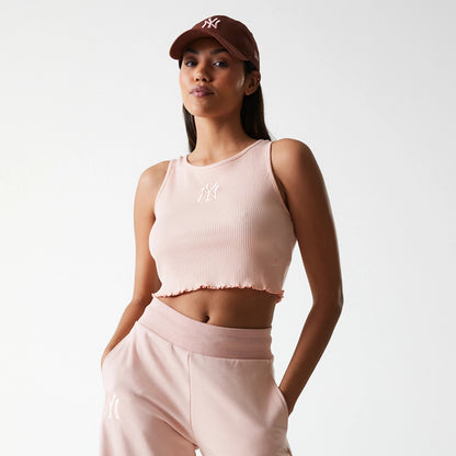 New Era New York Yankees Womens MLB Rib Pastel Pink Rib Tank Top, front view on a model styled with pastel pink joggers, featuring a white embroidered NY logo on the centre chest of the ribbed fabric.