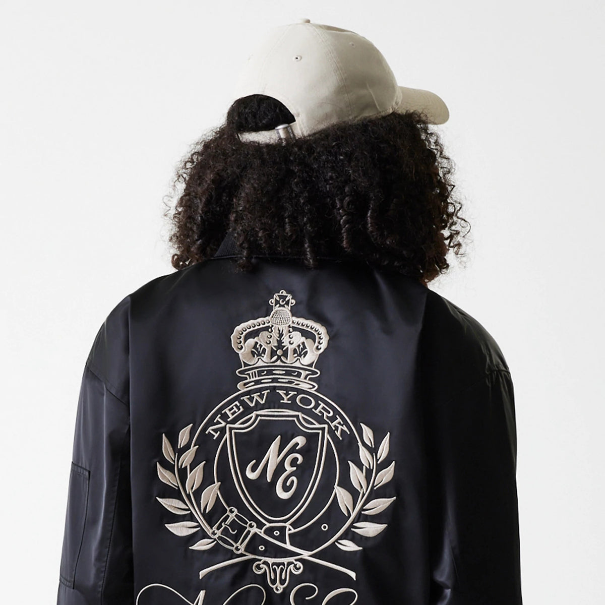 The Female model is wearing Womens New Era Satin Black Satin Bomber Jacket 5