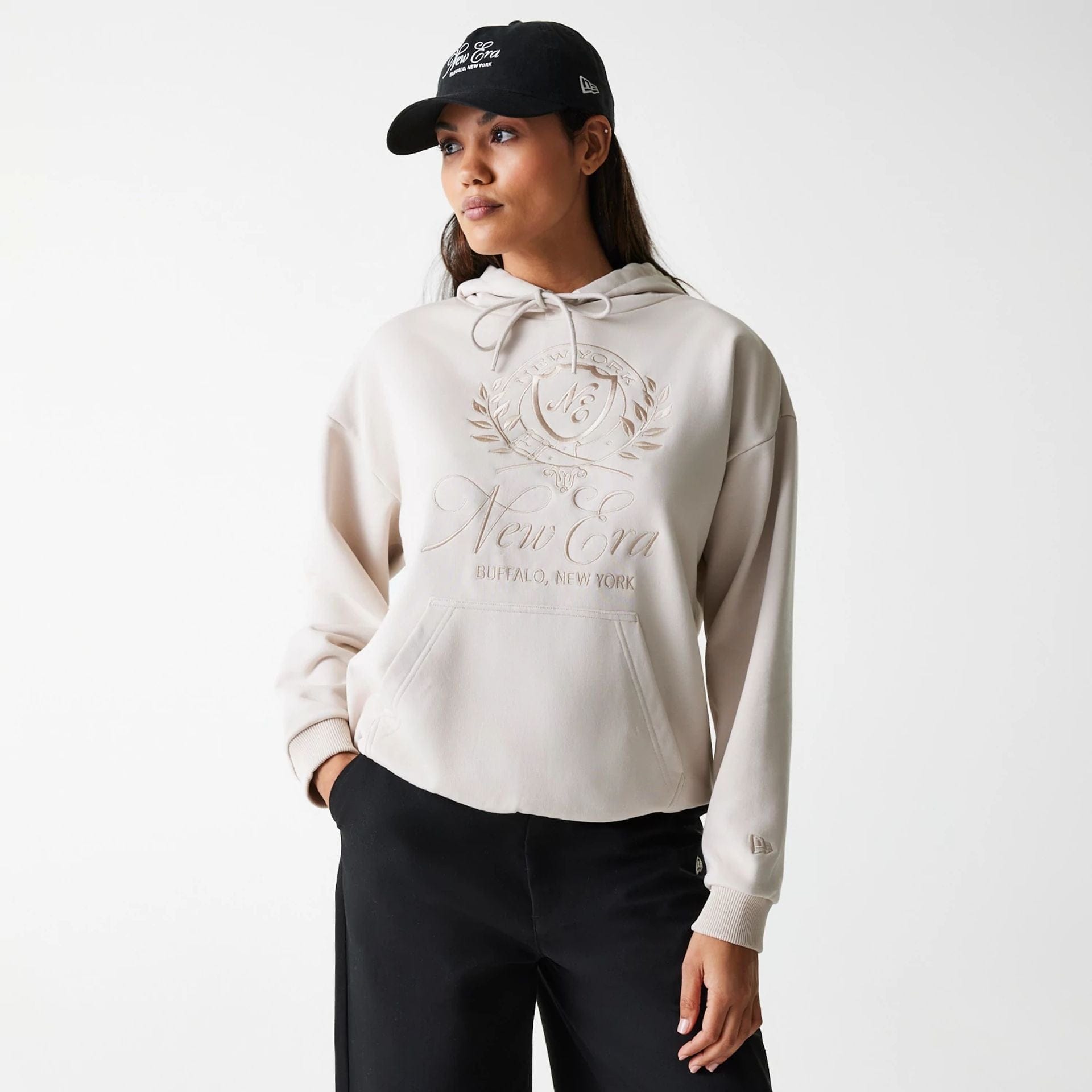 The Female model is wearing Womens New Era Crest Light Beige Pullover Hoodie 4