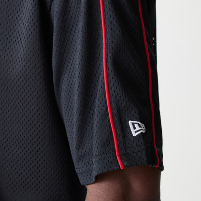 New Era Chicago Bulls NBA Piping Black Oversized Mesh T-Shirt, side view showing the black mesh fabric with distinctive red piping along the sleeve, featuring a raised New Era logo embroidered in white near the hem.