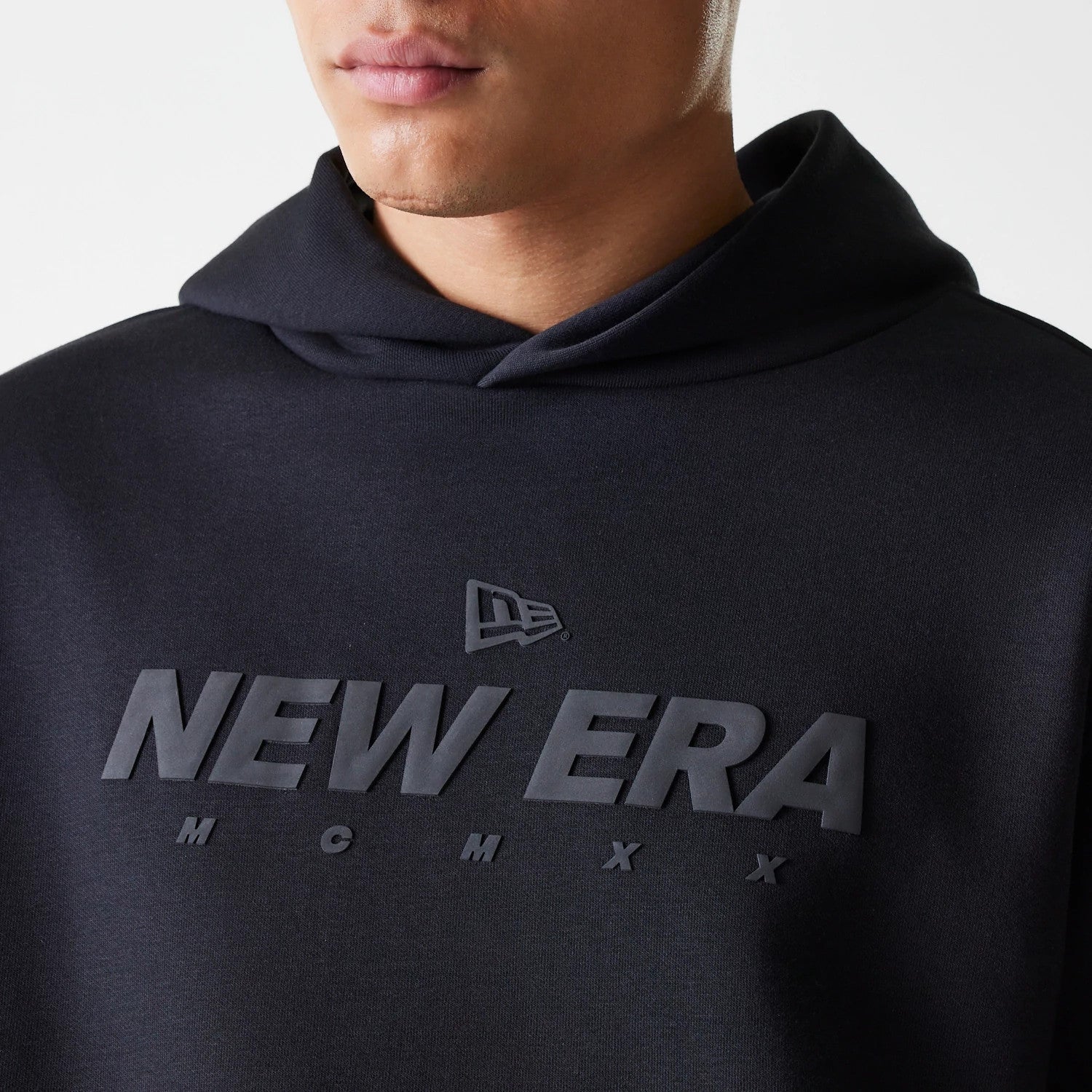 The Male model is wearing New Era Tech Black Oversized Pullover Hoodie 3