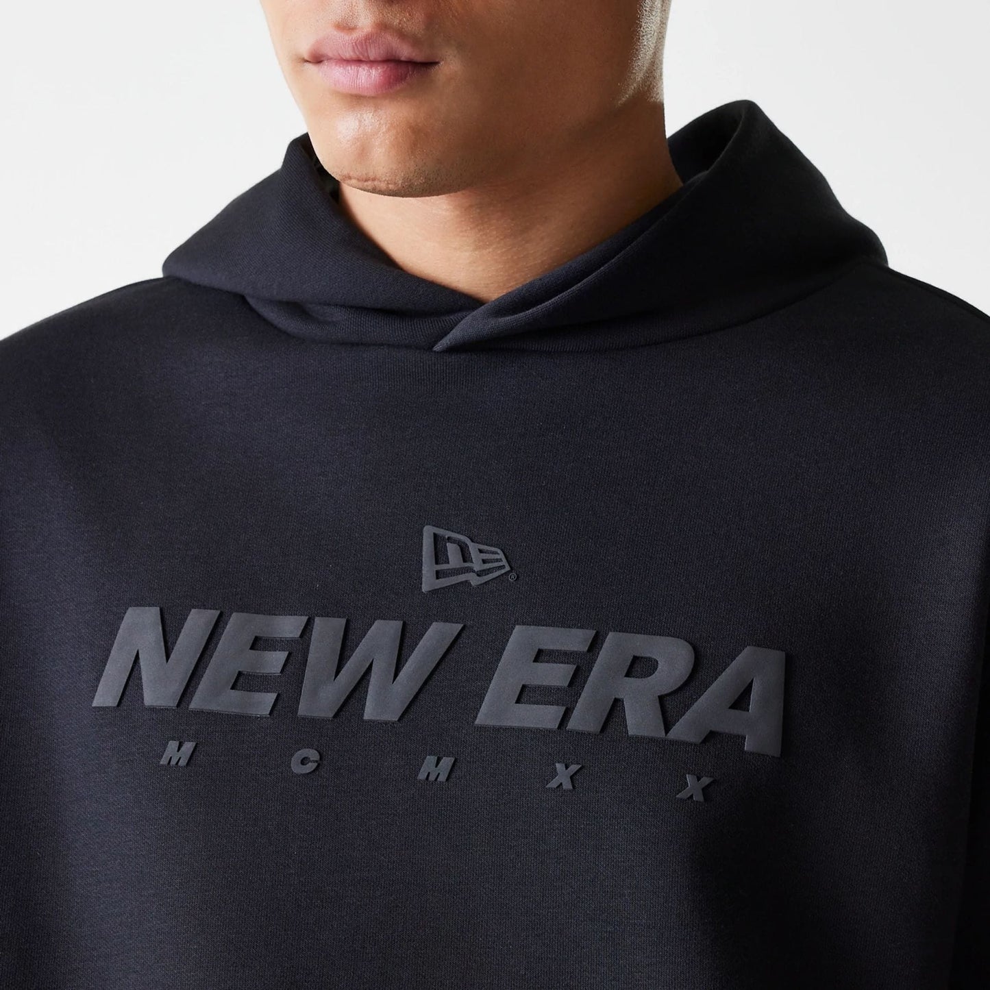 The Male model is wearing New Era Tech Black Oversized Pullover Hoodie 3