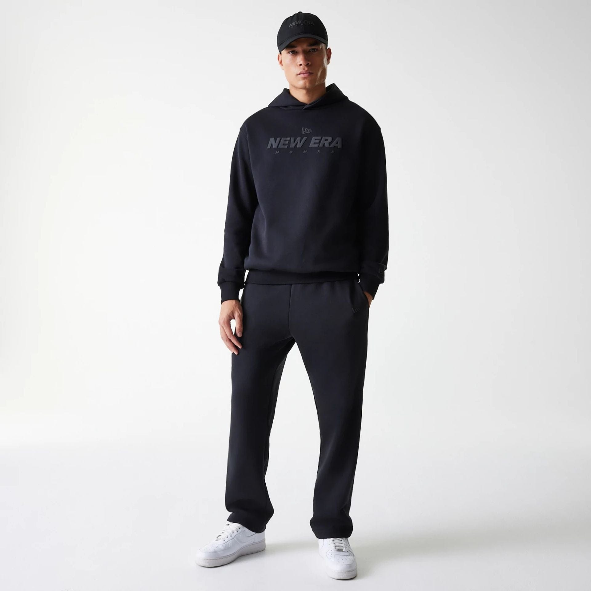 The Male model is wearing New Era Tech Black Oversized Pullover Hoodie 8