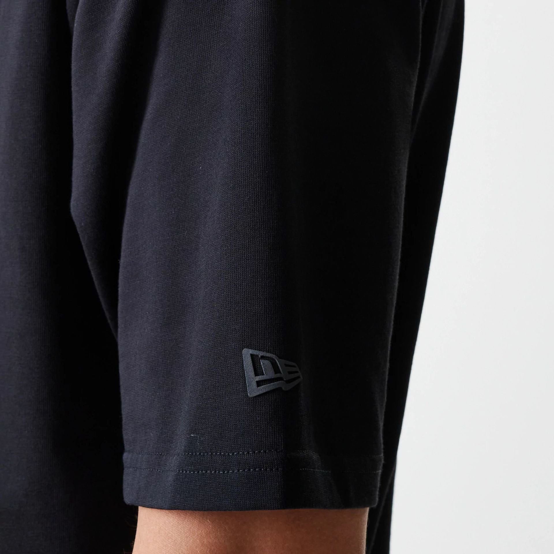 The Male model is wearing New Era Tech Black Oversized T-Shirt 7