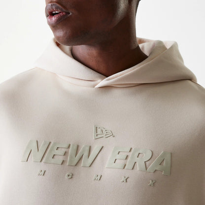 New Era Tech Light Beige Oversized Pullover Hoodie, front view showing a raised logo across the chest, a relaxed hood draping over the shoulders, and the light beige fabric complementing the minimalist design.