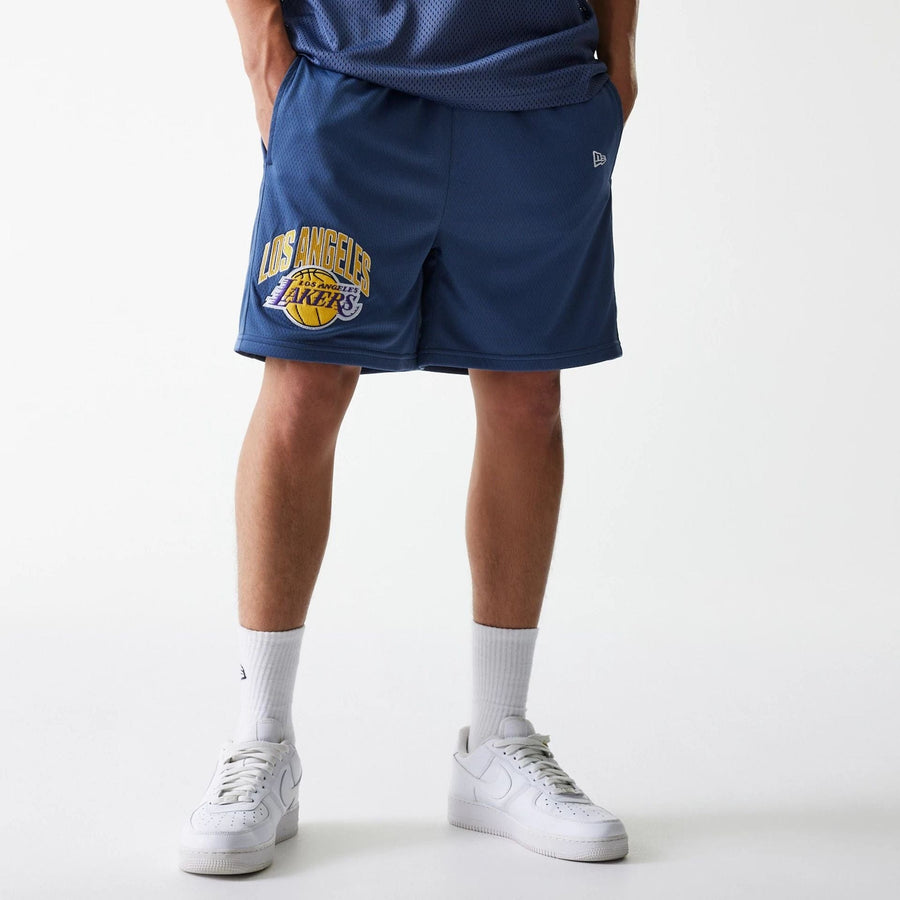 The Male model is wearing LA Lakers NBA Arch Graphic Dark Blue Mesh Shorts 1