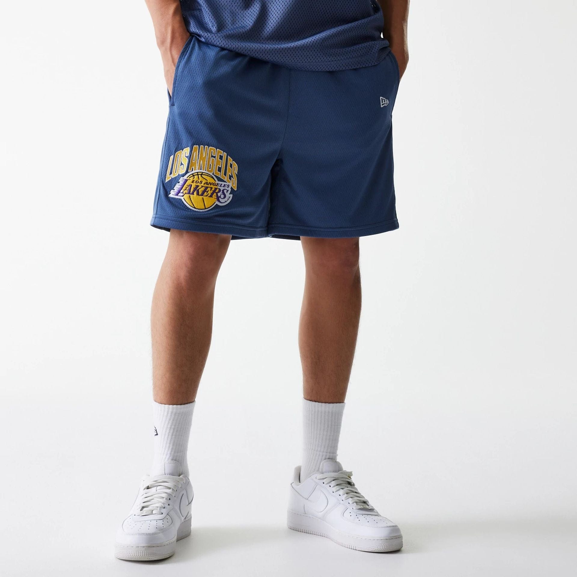 The Male model is wearing LA Lakers NBA Arch Graphic Dark Blue Mesh Shorts 1