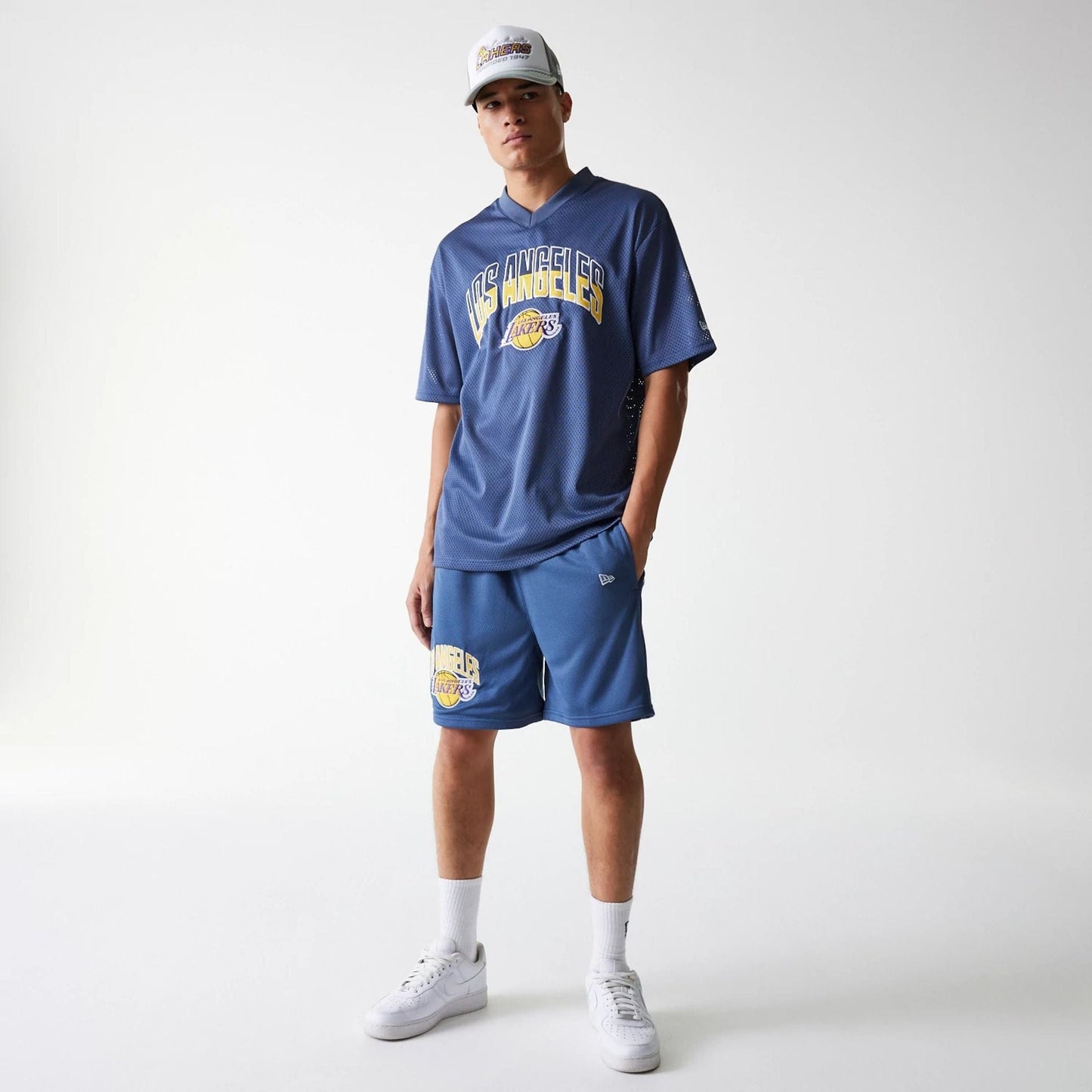 The Male model is wearing LA Lakers NBA Arch Graphic Dark Blue Mesh Shorts 8