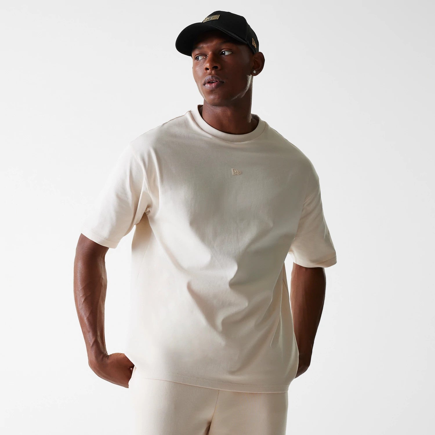 The Male model is wearing New Era Tech Light Beige Oversized T-Shirt 3
