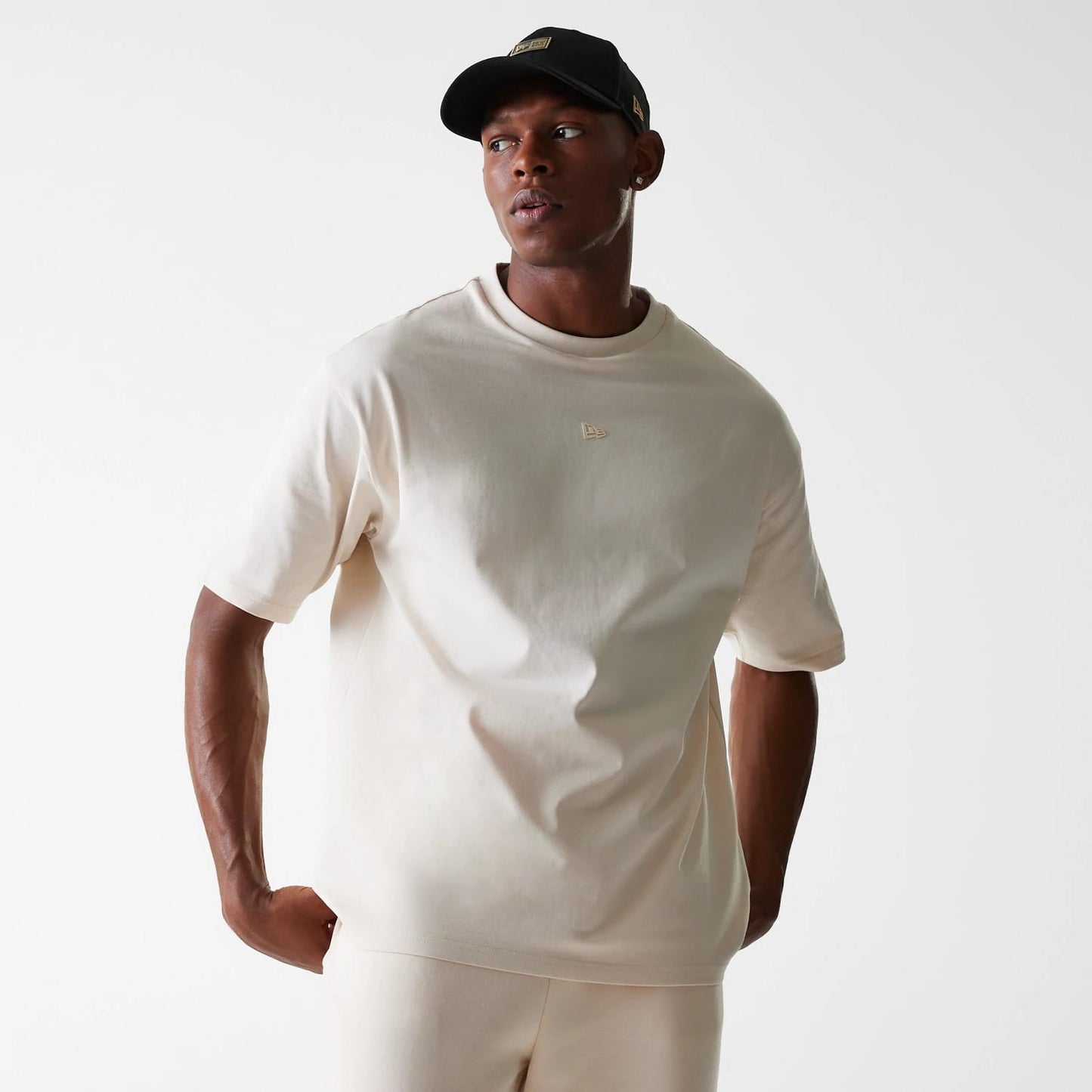 The Male model is wearing New Era Tech Light Beige Oversized T-Shirt 3