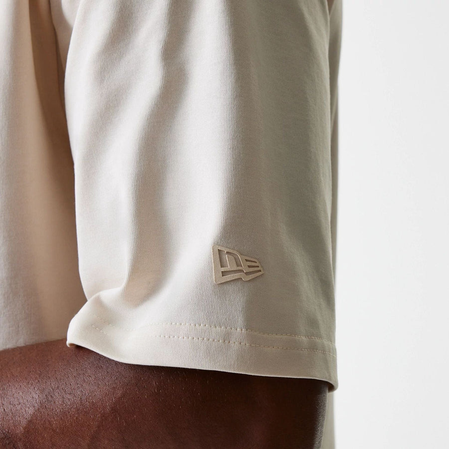 The Male model is wearing New Era Tech Light Beige Oversized T-Shirt 7