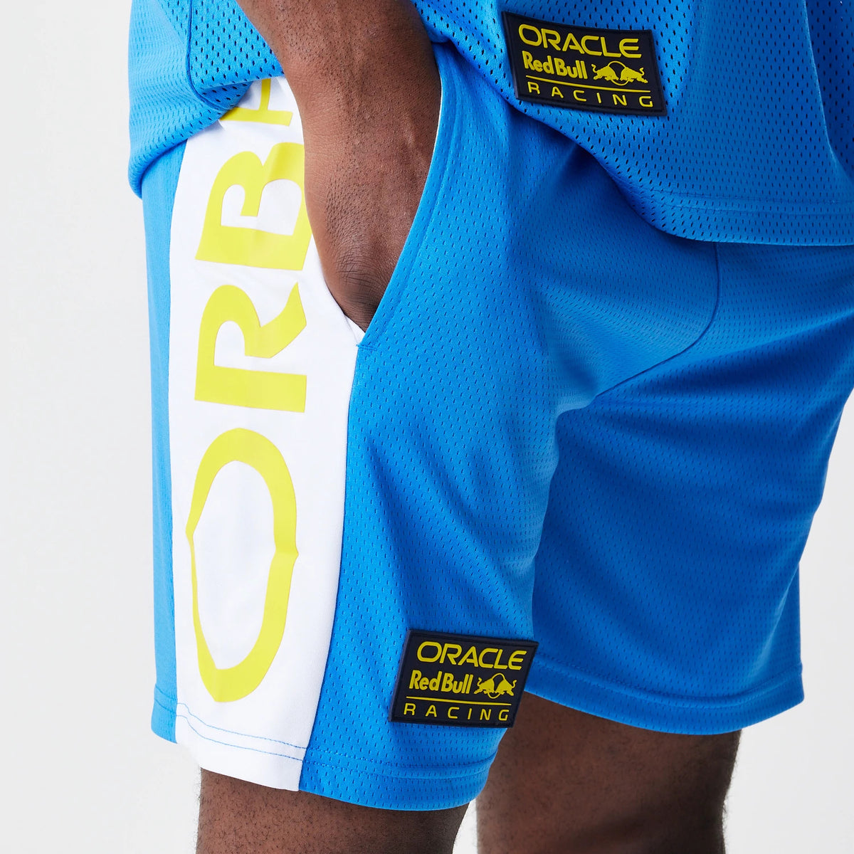 New Era Red Bull Racing Graphic Mesh Blue Shorts, three-quarter view showing a yellow and white graphic along the side seam, with an embroidered Oracle Red Bull Racing patch situated on the front left pocket area.