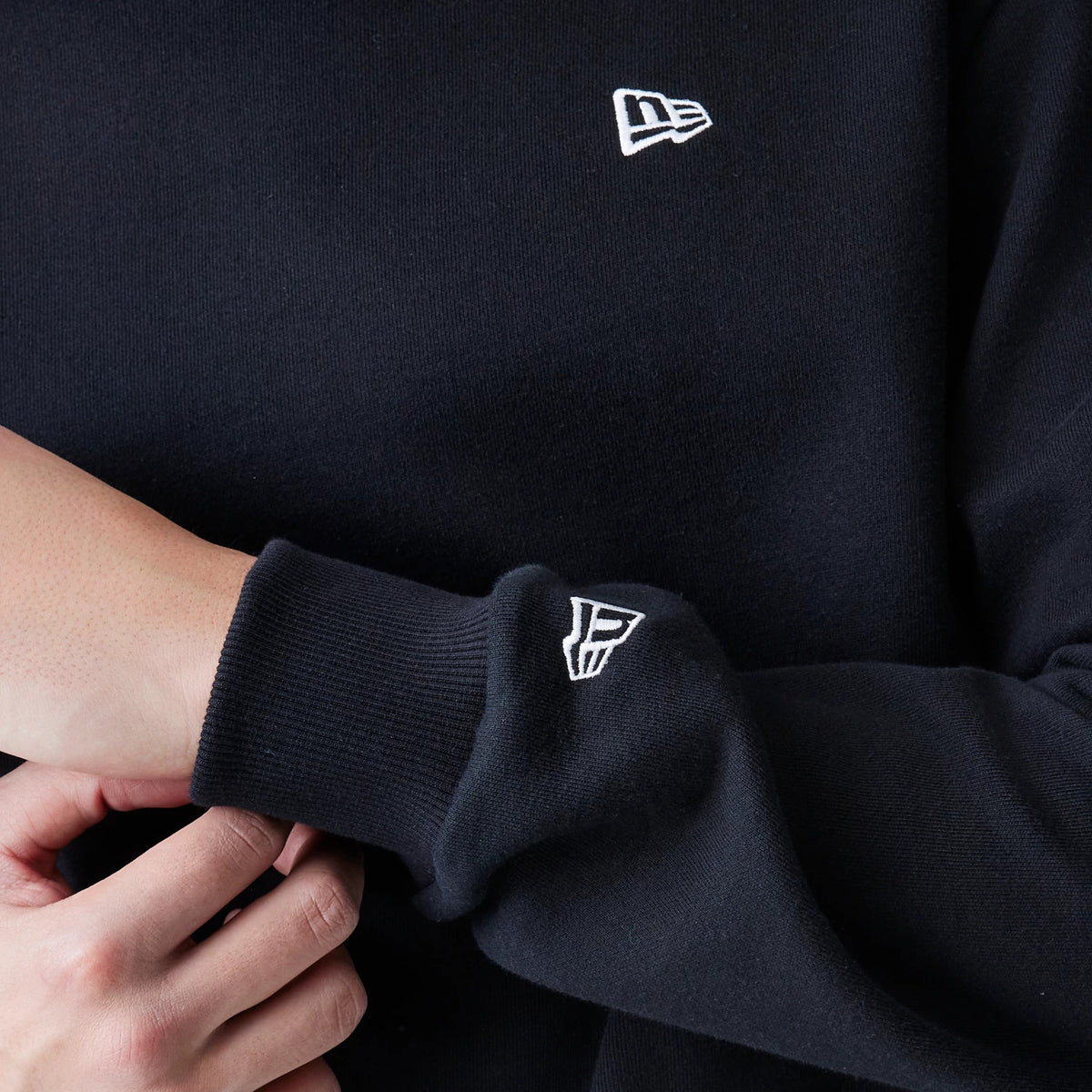 The Male model is wearing New Era Premium Essential Black Oversized Crew Neck Sweater 5