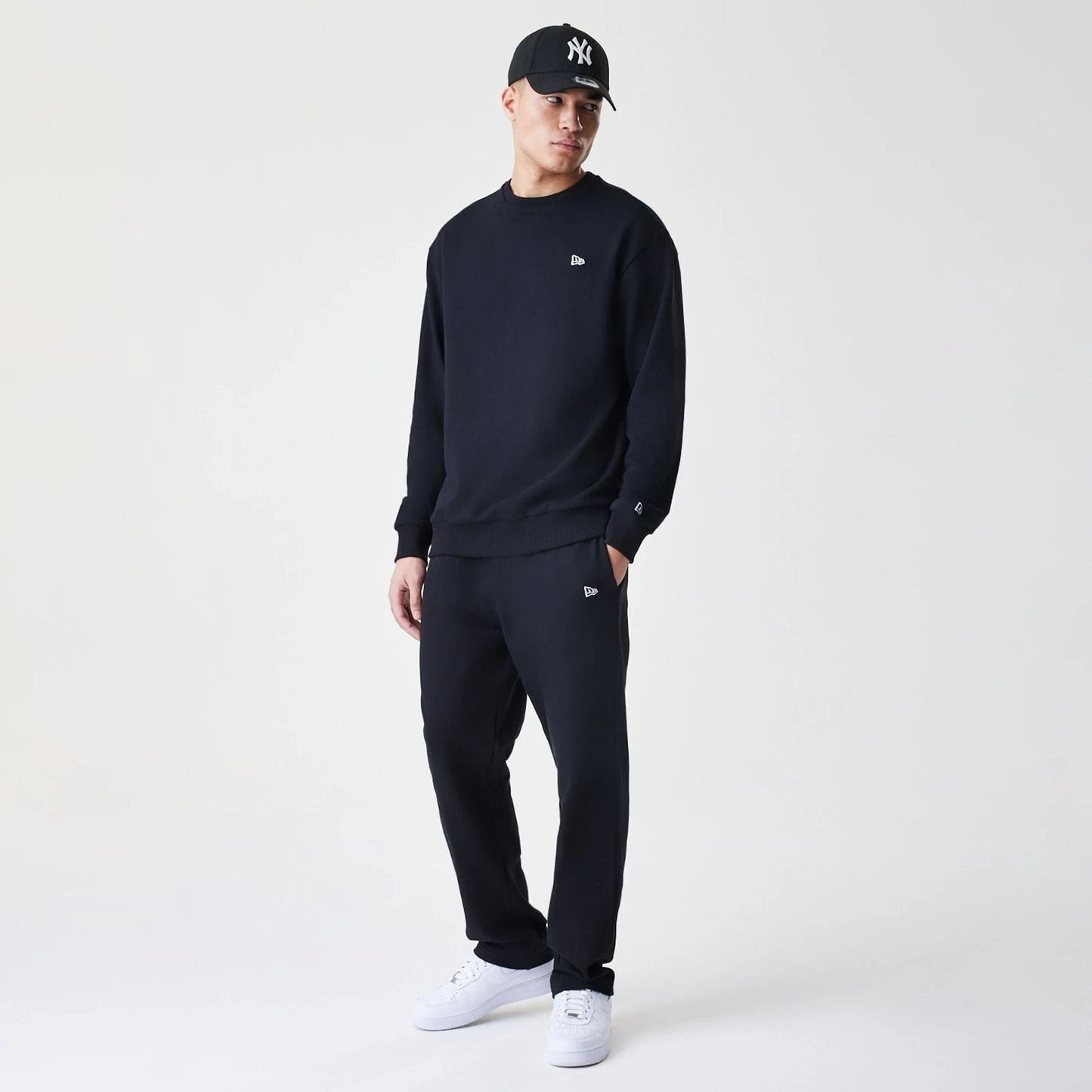 The Male model is wearing New Era Premium Essential Black Oversized Crew Neck Sweater 8