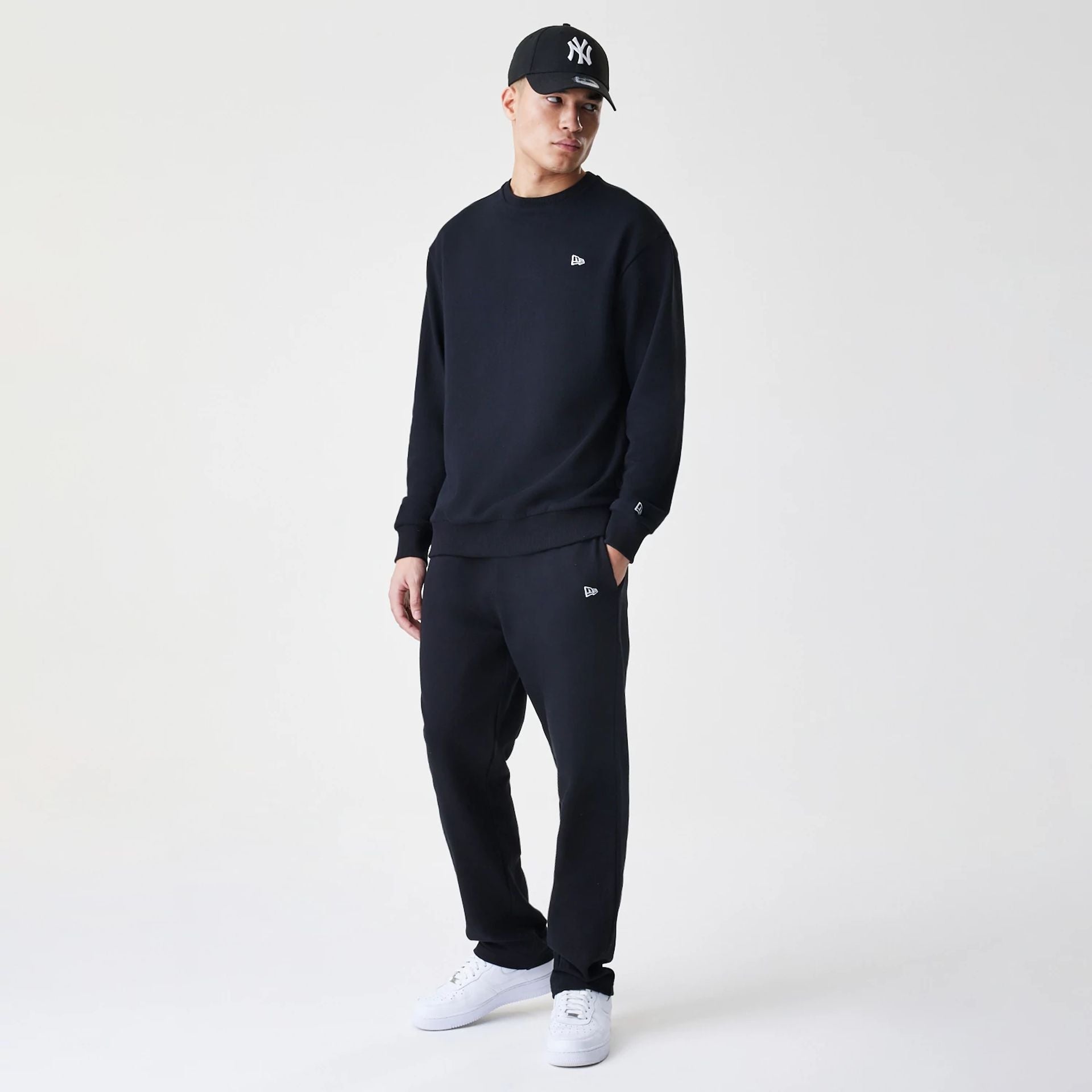 The Male model is wearing New Era Premium Essential Black Oversized Crew Neck Sweater 8