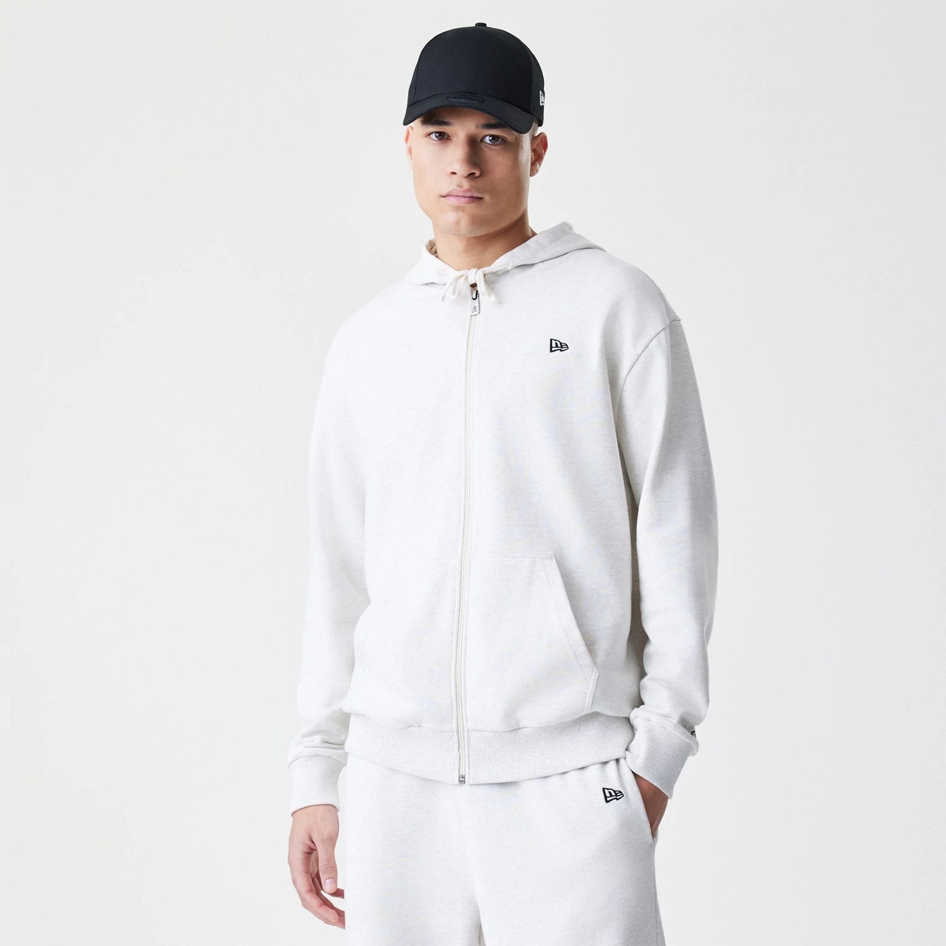 The Male model is wearing New Era Premium Essential Pastel Grey Oversized Full Zip Hoodie 1