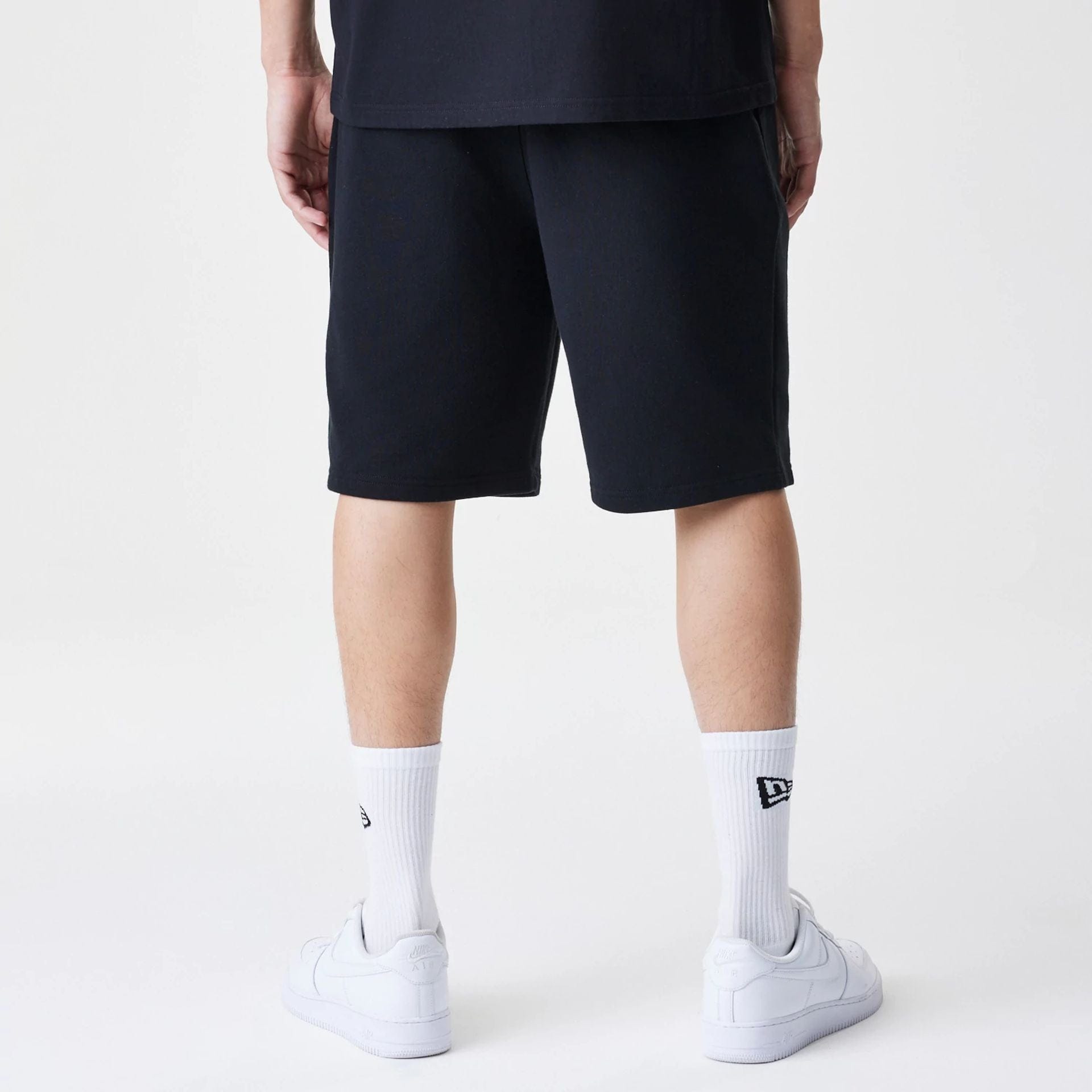 The Male model is wearing New Era Premium Essential Black Oversized Shorts 2