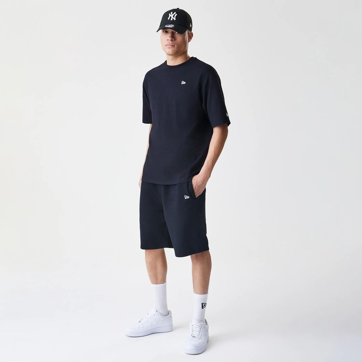 The Male model is wearing New Era Premium Essential Black Oversized Shorts 8
