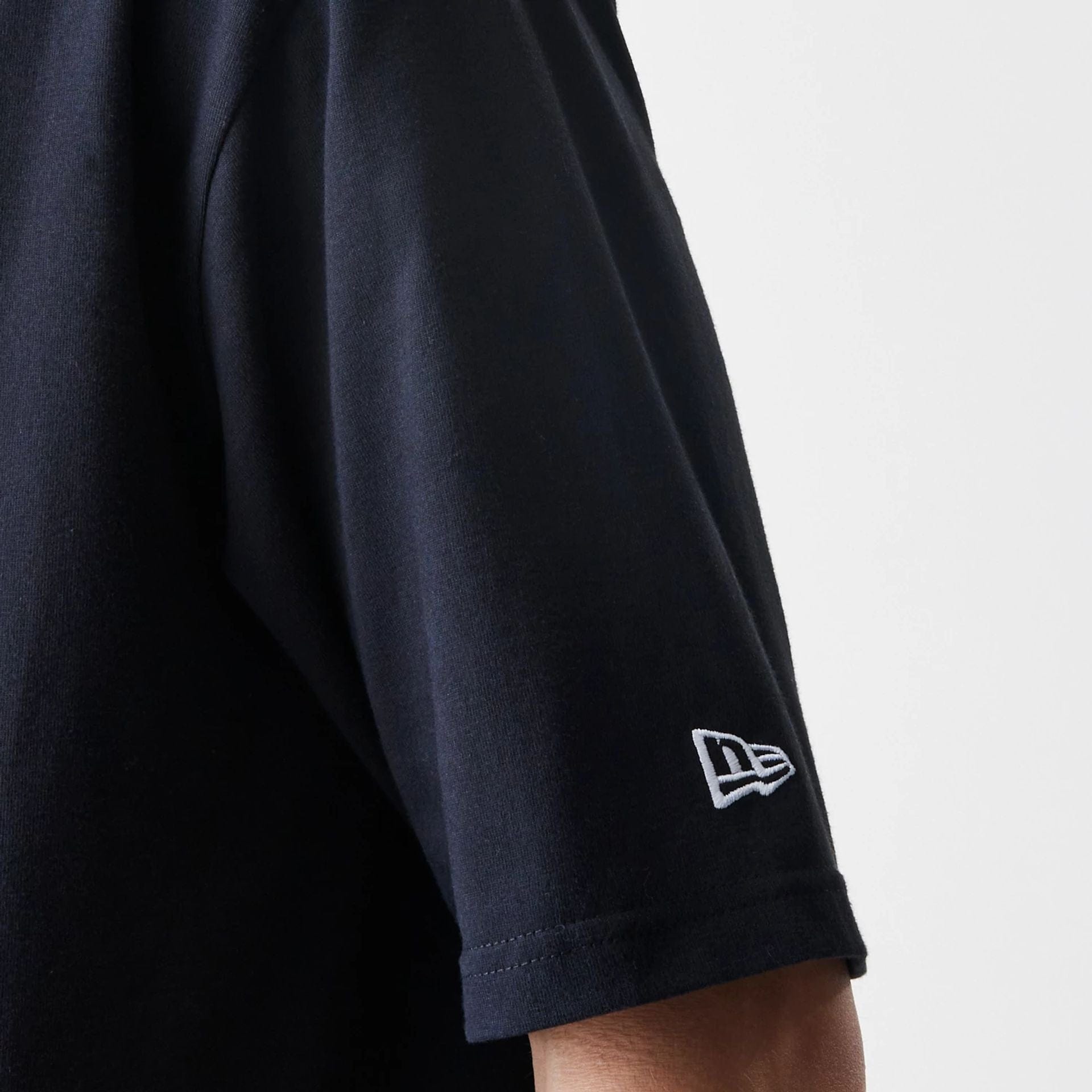 The Male model is wearing New Era Premium Essential Black Oversized T-Shirt 5