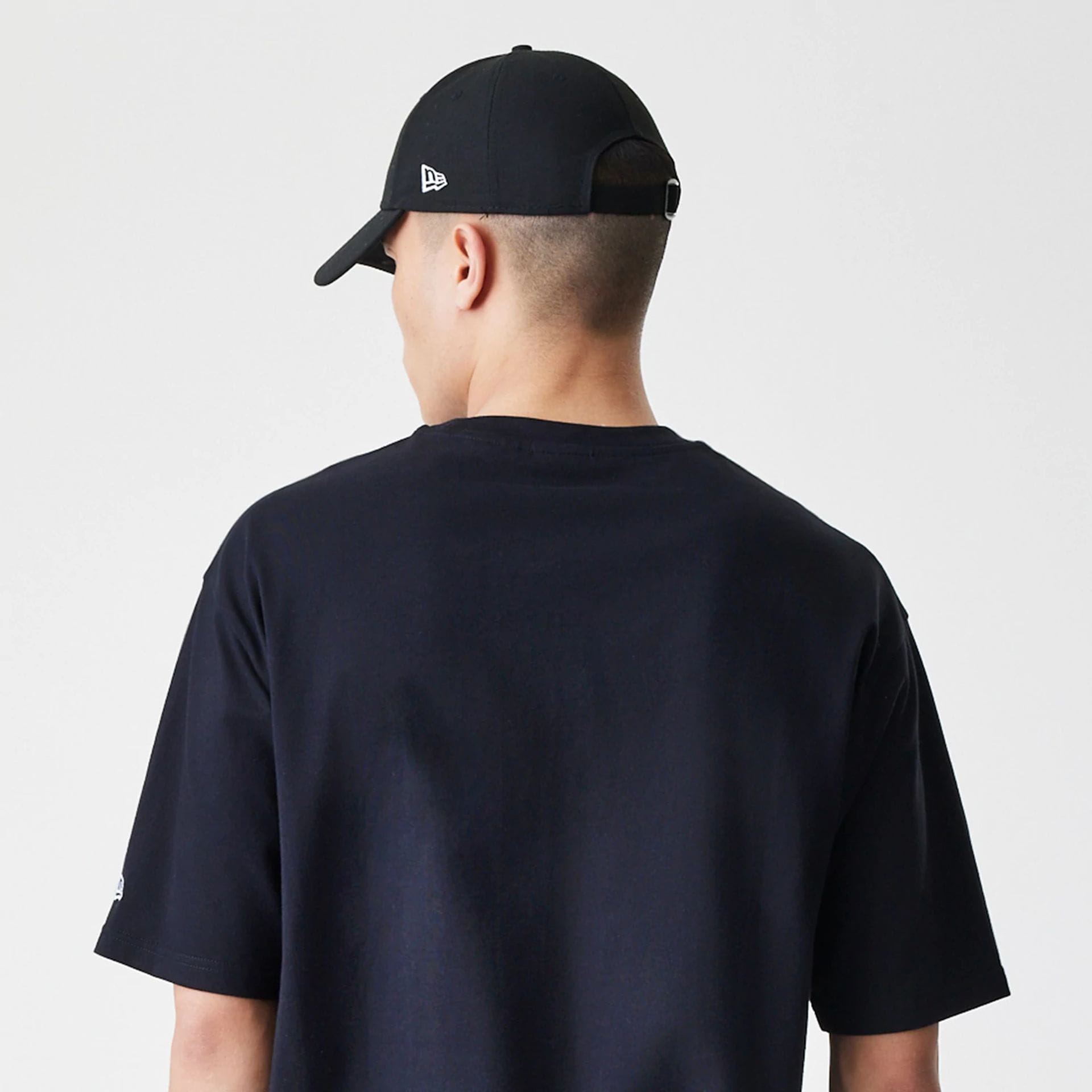 The Male model is wearing New Era Premium Essential Black Oversized T-Shirt 7