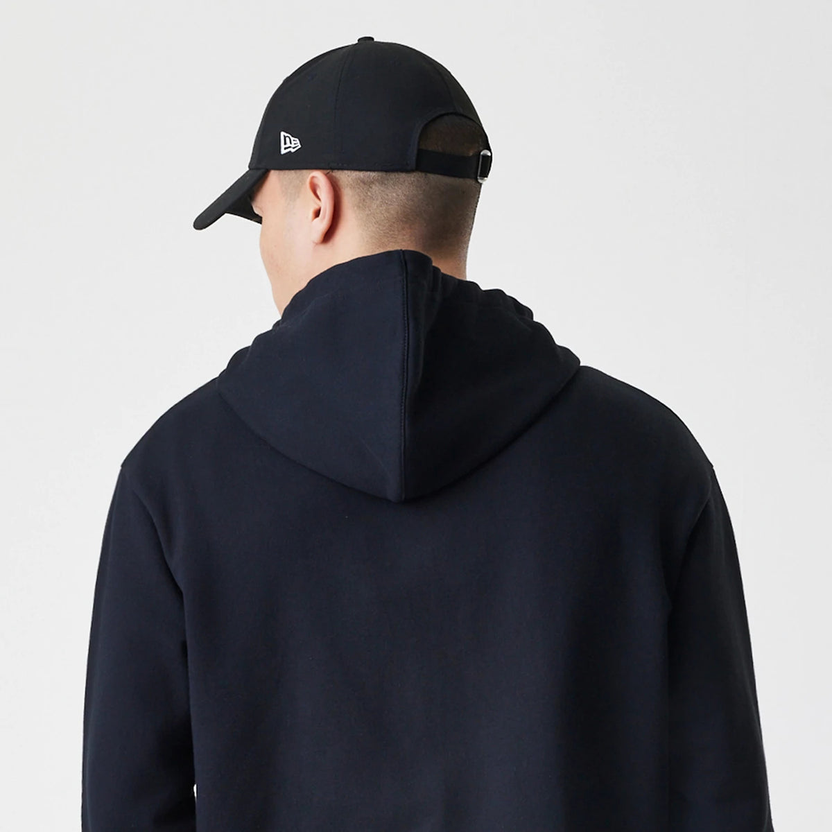 The Male model is wearing New Era Premium Essential Black Oversized Full Zip Hoodie 7