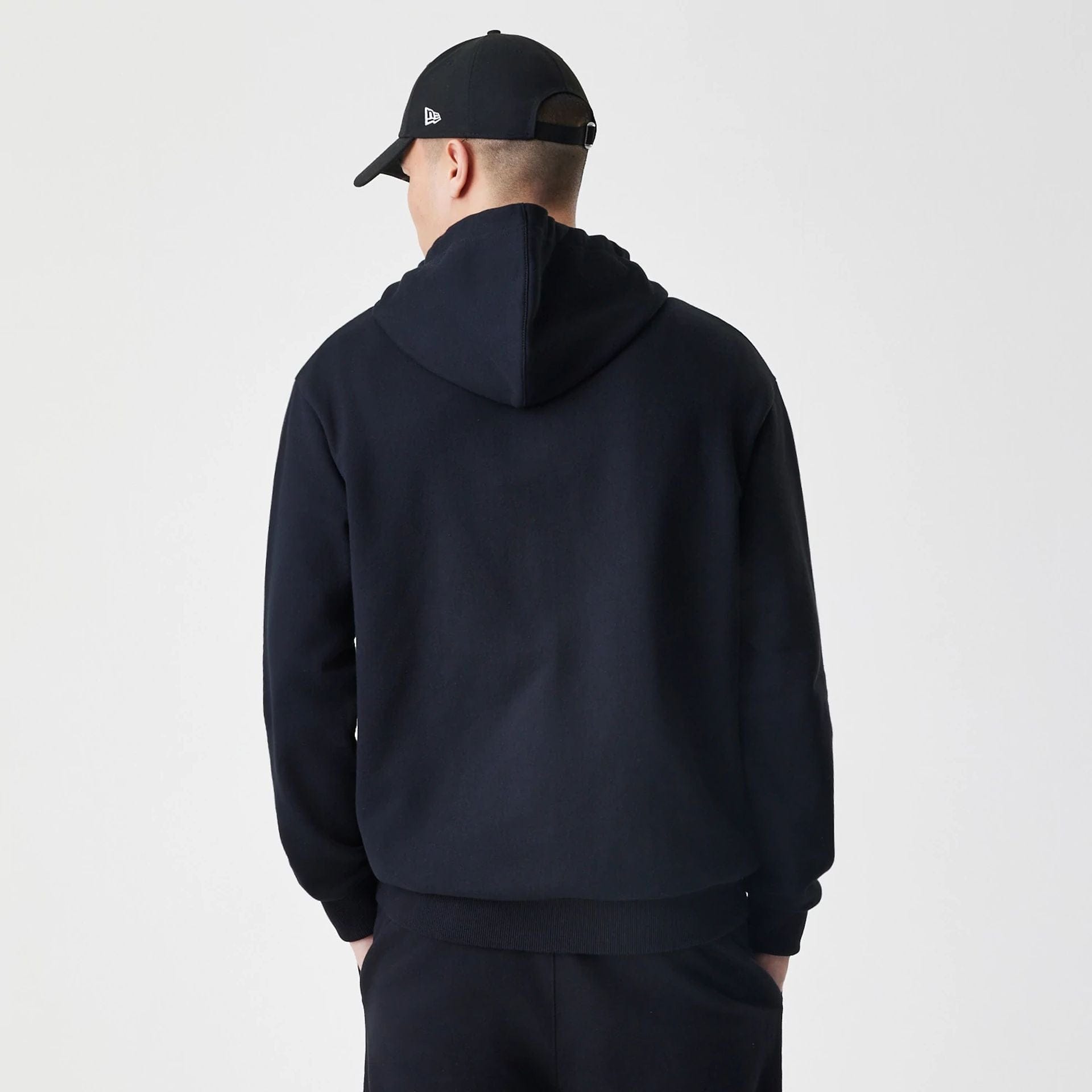 The Male model is wearing New Era Premium Essential Black Oversized Full Zip Hoodie 2