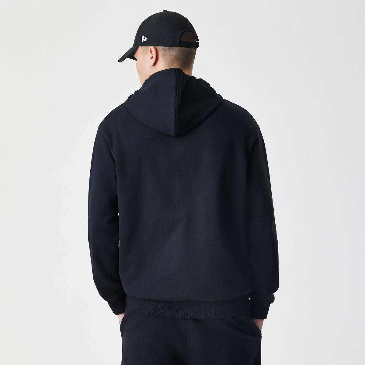 The Male model is wearing New Era Premium Essential Black Oversized Full Zip Hoodie 2
