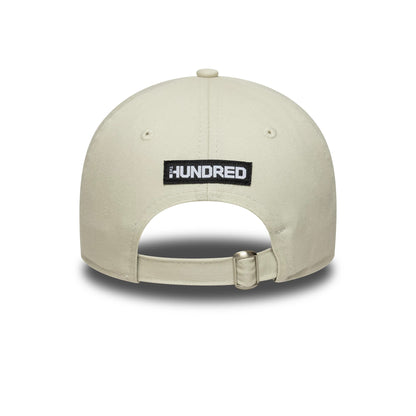 Oval Invincibles The Hundred 2025 Contrast Light Beige New Era 9TWENTY Adjustable Cap, rear view showing the black and white embroidered The Hundred logo on the back panel above the beige fabric strap with a buckle.