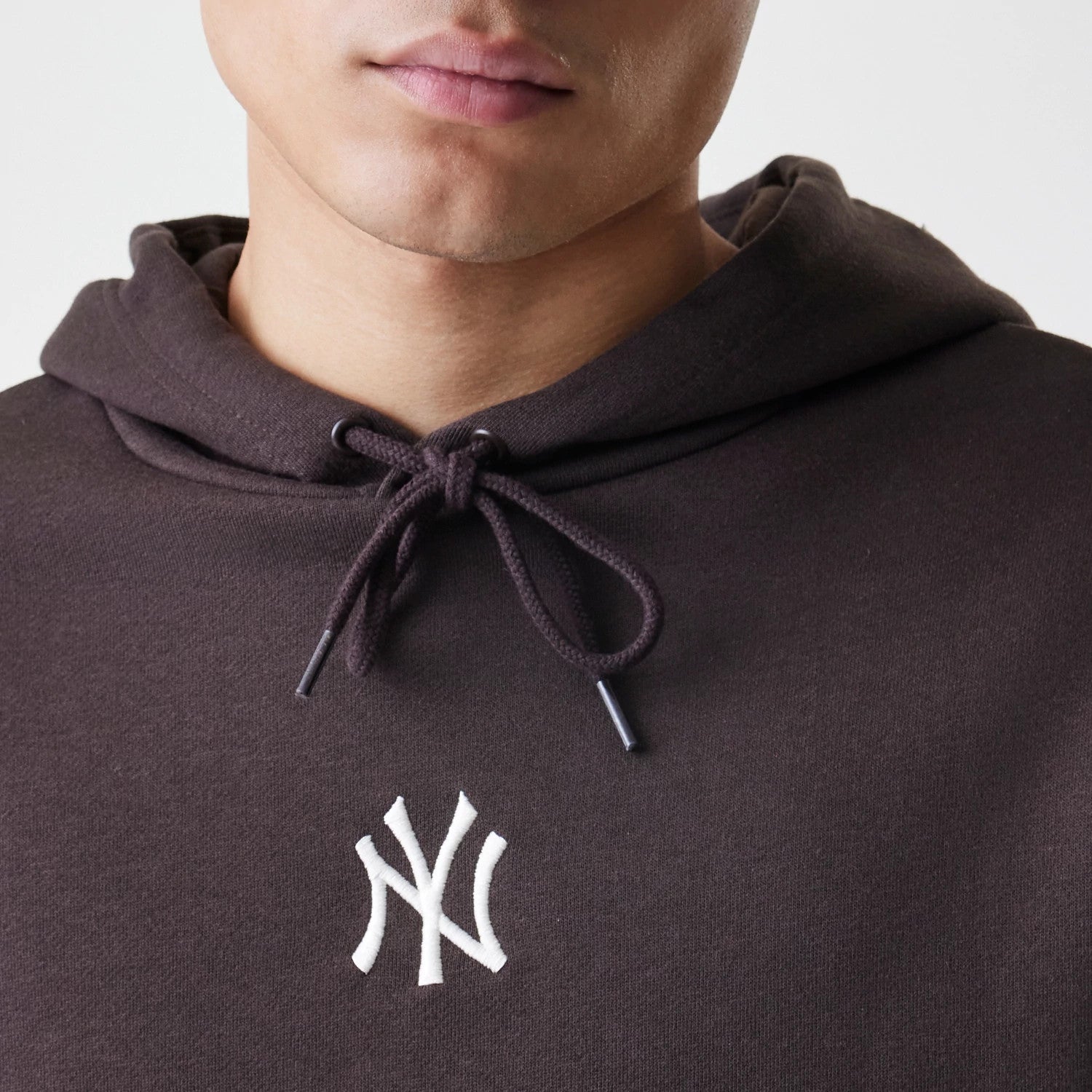 The Male model is wearing New York Yankees MLB Midi League Essential Dark Brown Oversized Pullover Hoodie 3