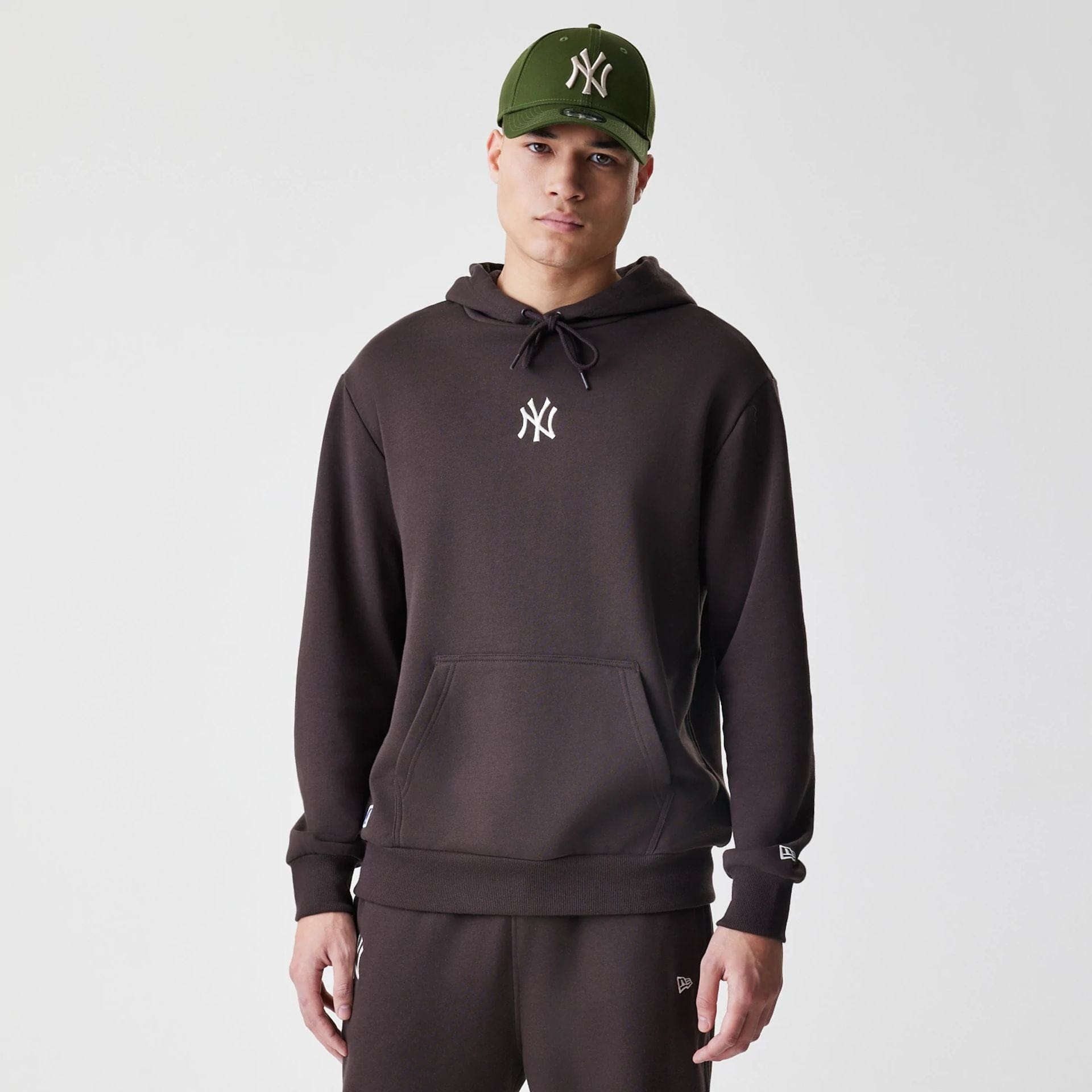 The Male model is wearing New York Yankees MLB Midi League Essential Dark Brown Oversized Pullover Hoodie  1