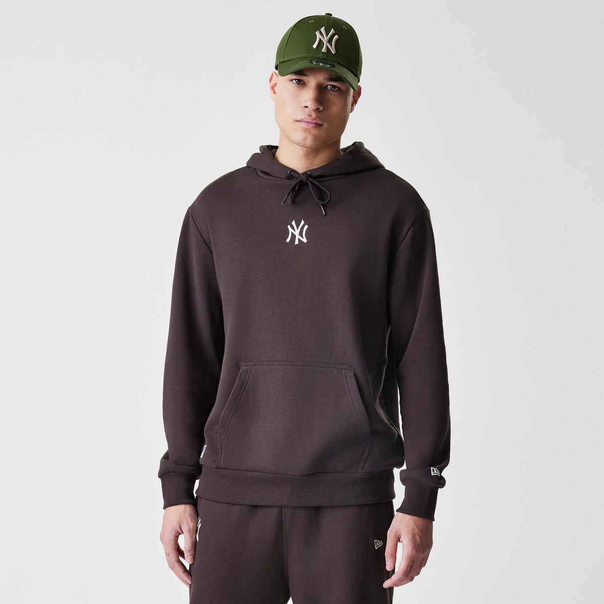 The Male model is wearing New York Yankees MLB Midi League Essential Dark Brown Oversized Pullover Hoodie 1