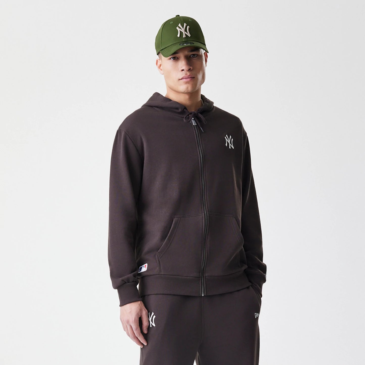 The Male model is wearing New York Yankees MLB Midi League Essential Dark Brown Full Zip Hoodie 3
