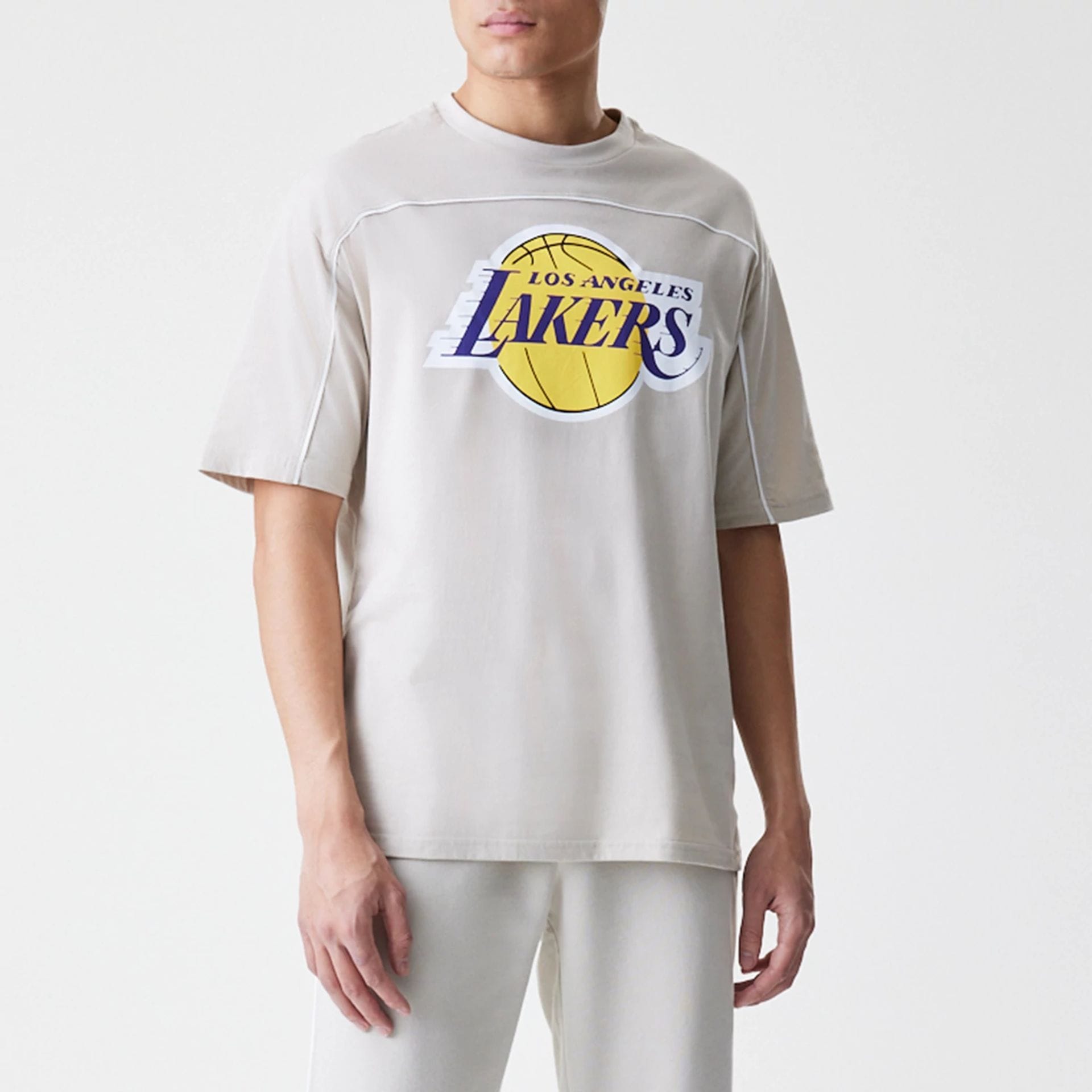 The Male model is wearing LA Lakers NBA Piping Light Beige Oversized T-Shirt  1