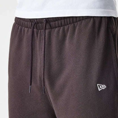 New Era New York Yankees MLB Midi League Essential Dark Brown Joggers, close-up view showing the elasticated waistband with drawstring, and the white embroidered New Era flag logo on the left thigh.