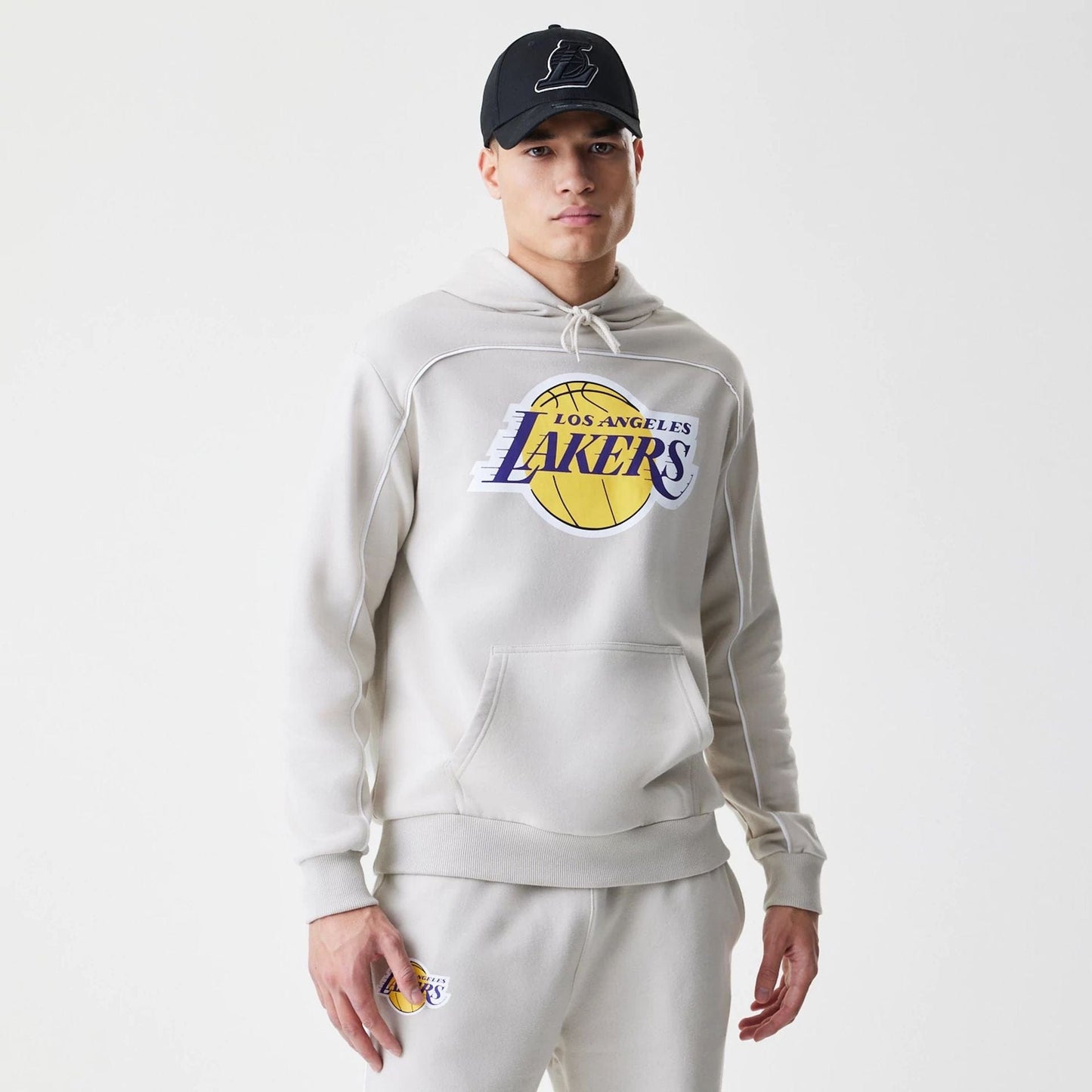 The Male model is wearing LA Lakers NBA Piping Cream Oversized Pullover Hoodie  1