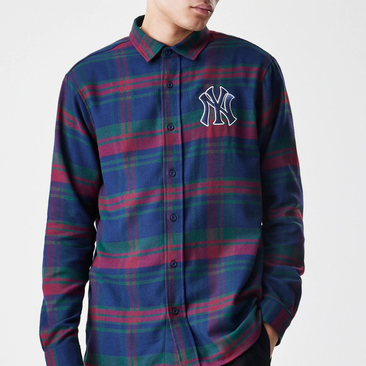 New Era New York Yankees MLB Check Navy Long Sleeve Shirt, front view on a model showing an embroidered white Yankees logo on the left chest and a navy, red, and green check pattern with button fastening.