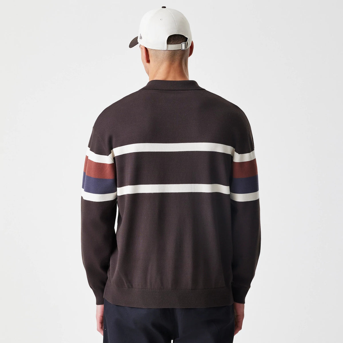 New Era LA Dodgers MLB Knit Brown Rugby Shirt, back view on a model wearing a light cap, showing white horizontal stripes across the back and dark brown fabric with additional multicoloured stripes on the sleeves.