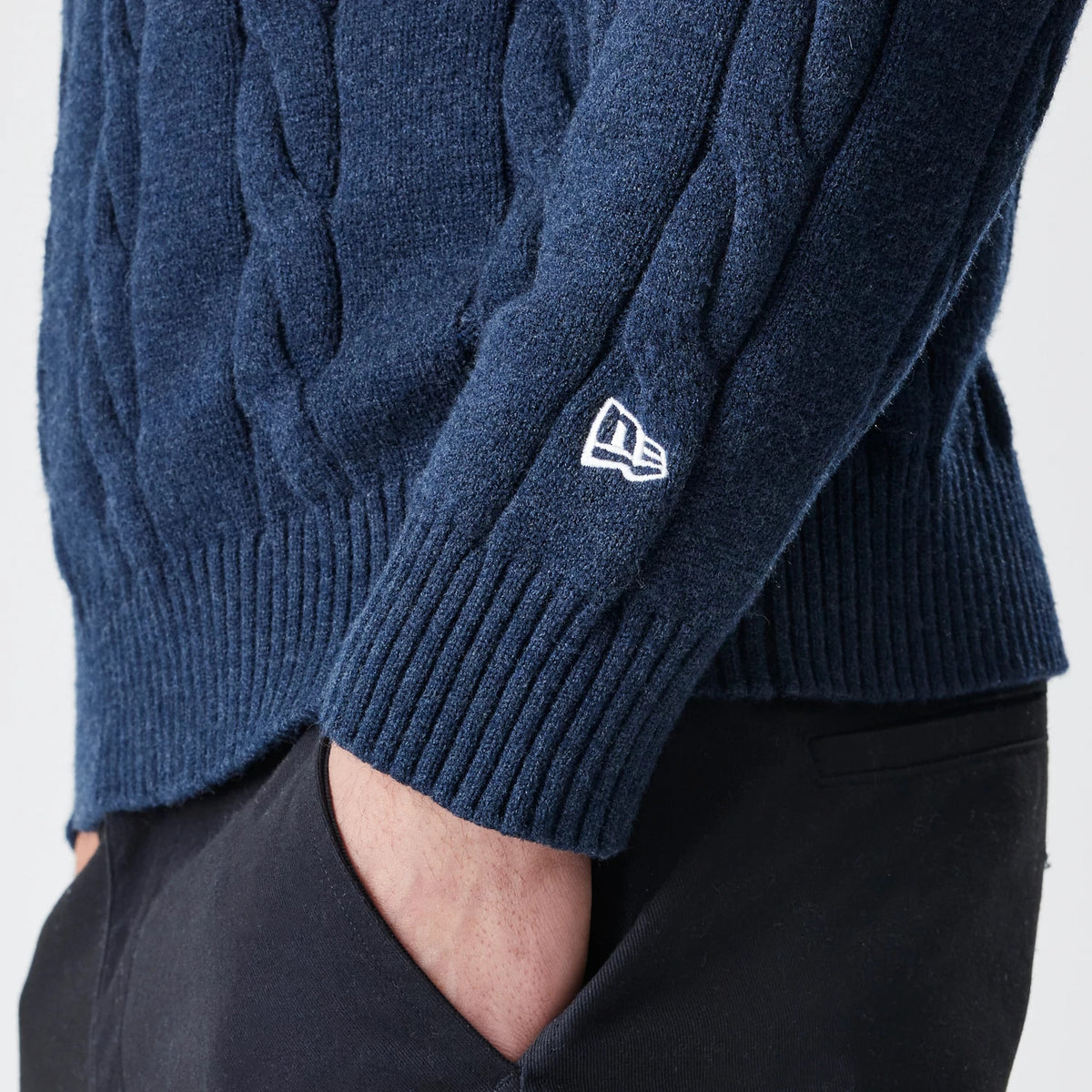New Era New York Yankees MLB Cable Knit Navy Knitted Sweater, close-up view showing the detailed cable knit texture and the white New Era flag logo embroidered above the ribbed cuff on the sleeve.