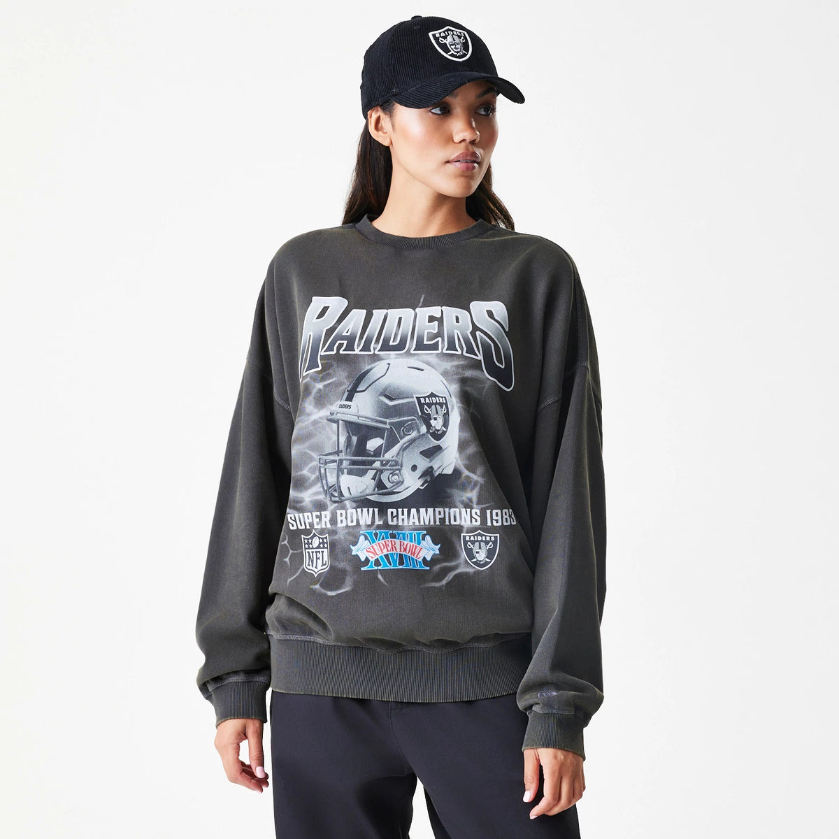 New Era Las Vegas Raiders NFL Washed Boxy Dark Grey Oversized Crew Neck Sweater, on-model front view featuring Raiders and helmet graphics across the chest, with Super Bowl Champions 1983 text and NFL logos at the bottom.
