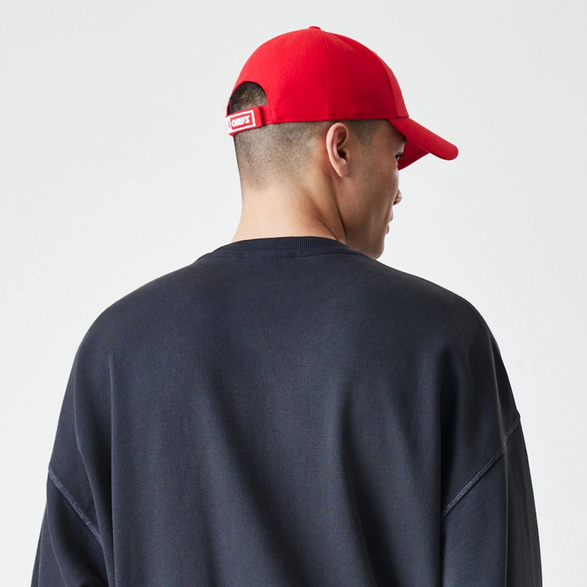 The Male model is wearing Kansas City Chiefs NFL Washed Boxy Black Oversized Crew Neck Sweater  7