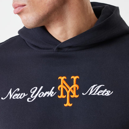 New Era New York Mets MLB Script Black Oversized Pullover Hoodie, front view on-model showing the orange embroidered team logo centred between white scripted New York Mets lettering across the chest, with the navy hood draped around the neckline.