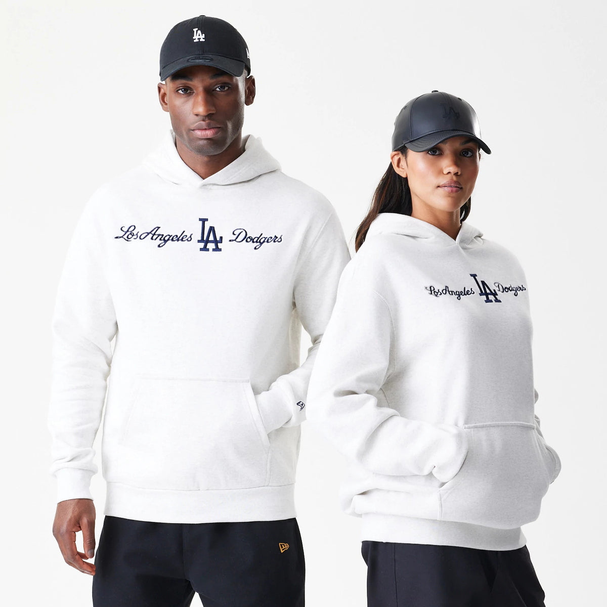New Era LA Dodgers MLB Script White Oversized Pullover Hoodie, front view on-model showing the embroidered Los Angeles Dodgers script in navy across the chest with a navy LA logo beneath, and a small New Era logo on the left sleeve cuff.