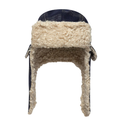 New Era Loden Navy Trapper Hat, front view showing cream faux shearling lining covering the face opening and ear flaps, with a navy exterior at the top and edges of the design.