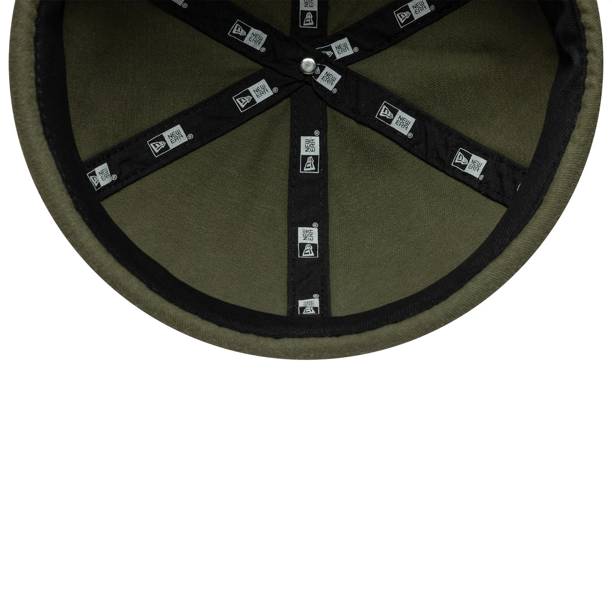 New Era Washed Cotton Green Docker Adjustable Hat, inside view showing black taping with repeated New Era logos, green fabric and a black sweatband along the edge.