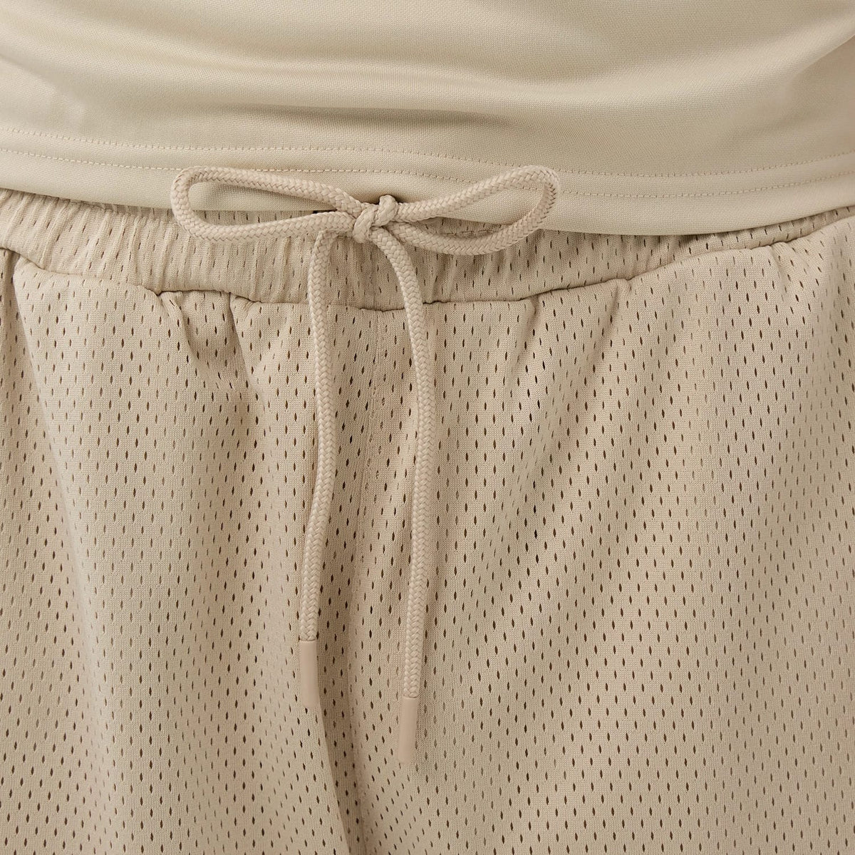The Male model is wearing New Era Mesh Light Beige Mesh Shorts 5