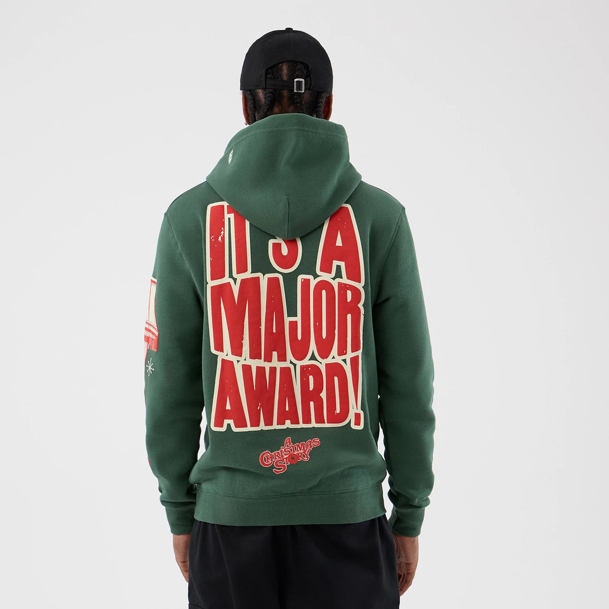 New Era A Christmas Story Major Award Dark Green Pullover Hoodie, back view on a model with red and white lettering reading IT'S A MAJOR AWARD! covering the back and a Christmas Story logo at the lower edge.