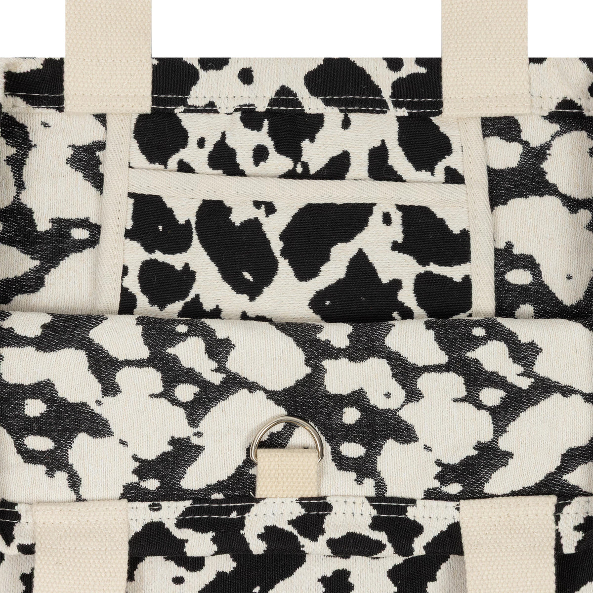 New Era New York Yankees MLB Cow Jacquard Cream Tote Bag, front view showing the intricate black and cream cow pattern, two beige handles, and a ring detail near the top centre, with a pocket design integrated.