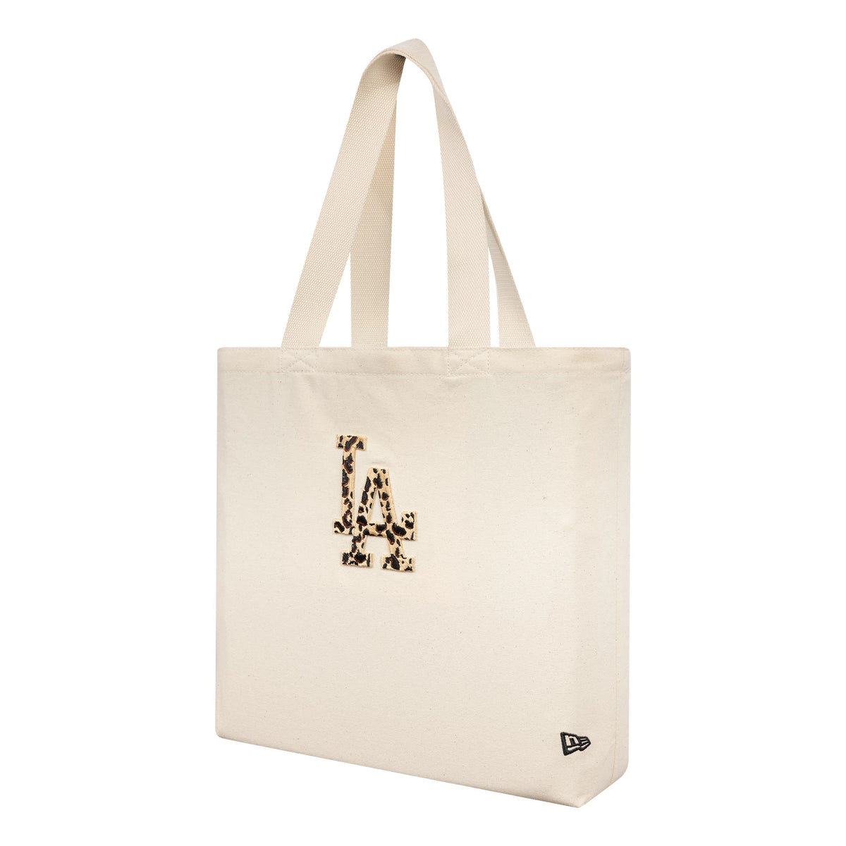 New Era LA Dodgers MLB Animal Infill Cream Tote Bag, three-quarter view showing the cream tote with dual shoulder straps, an embroidered LA logo with animal print on the front, and a small debossed New Era logo near the base corner.
