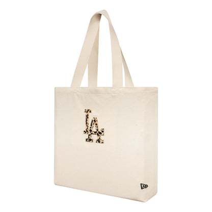 New Era LA Dodgers MLB Animal Infill Cream Tote Bag, three-quarter view showing the cream tote with dual shoulder straps, an embroidered LA logo with animal print on the front, and a small debossed New Era logo near the base corner.